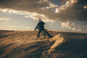 Dirt bike and rider wearing motorcycle jacket and helmet